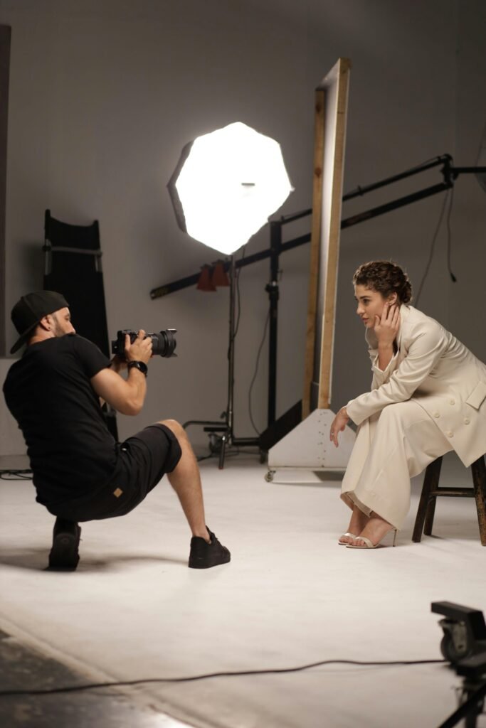 Elegant woman being photographed in a modern studio with professional lighting.